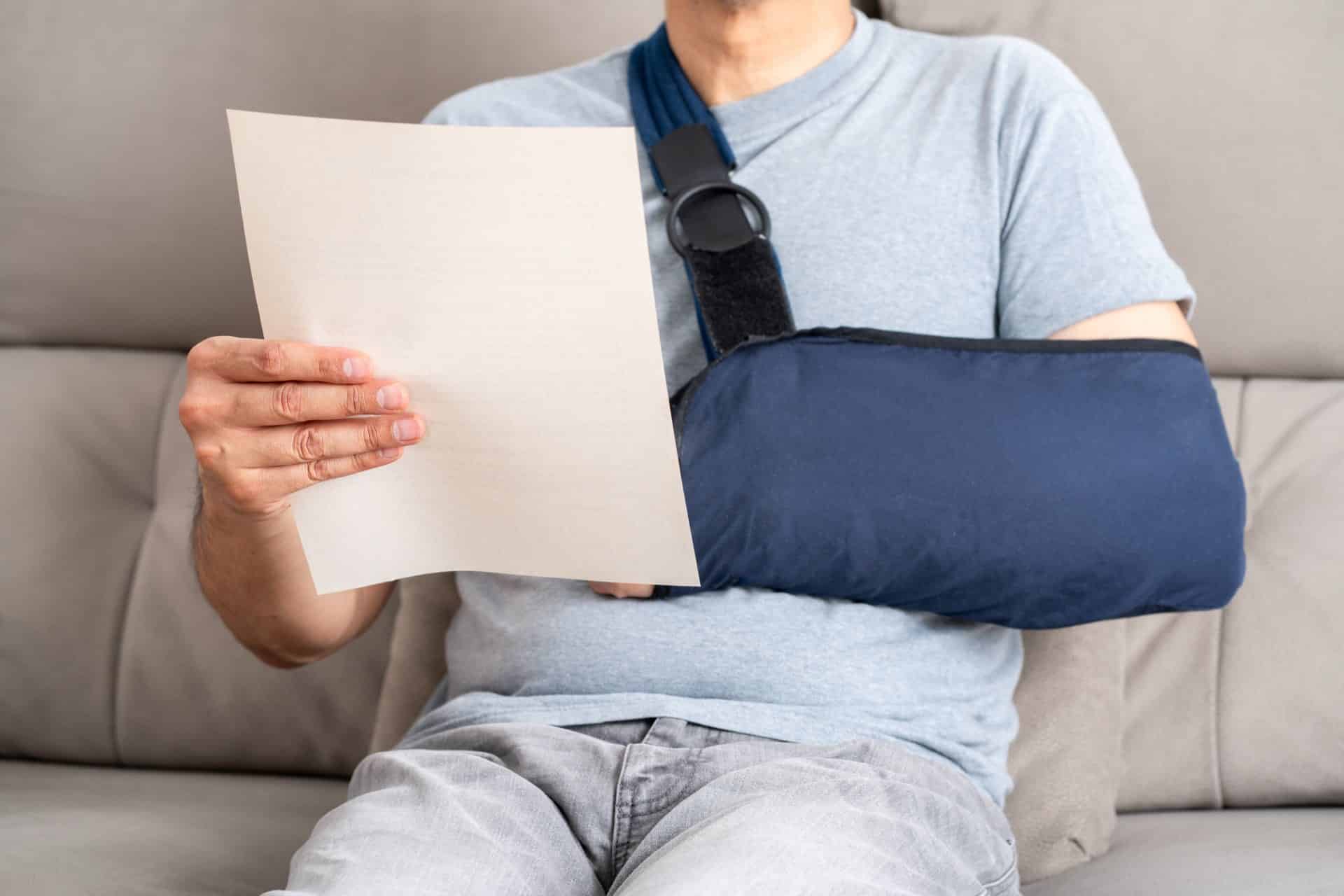 Person in blue cast holding a piece of paper